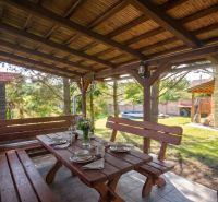 Covered outdoor seating area in a family house in Dobrá Voda with wooden furniture.