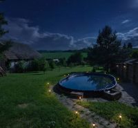 The night garden of a family house in Dobrá Voda with an illuminated pool.