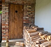 Wooden door with a stack of wood at a family house in Dobrá Voda, street 240.