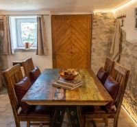 Dining table with wood decor and stone wall in a family house.