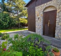 A stone-clad family house on 240 Street in Dobrá Voda with an ornamental garden.