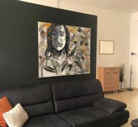 Living room with a gray sofa, a striking painting, and light tiles in a 2-room apartment.