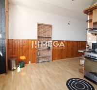 A kitchen in a 3-room apartment with a wooden decor floor and brick cladding.