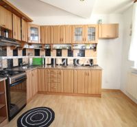 A kitchen in a 3-room apartment with a wooden decor floor and a functional kitchen unit.
