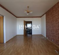 A room in a 3-room apartment with a wooden decor floor and a brick pattern on the wall.