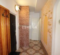 A hallway in a 3-room apartment with a decorative wall and patterned tiles.
