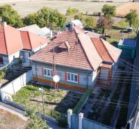 A family house in Kráľov Brod with a traditional roof, surrounding gardens and fields.