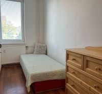A room in a 2-room apartment with a bed, a dresser, and a floor with a wooden decor.