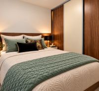 Bedroom in a 2-room apartment, combination of wood-decor flooring and elegant furniture.