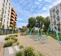 Children are playing in the playground between apartment buildings at Muchovo Square in Bratislava.