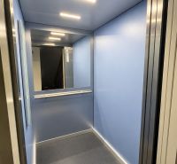 Blue elevator cabin with lighting and a mirror on the back wall.