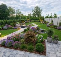 The garden of a family house in Hôrka nad Váhom with landscaped flower beds, a walkway, and outdoor seating.