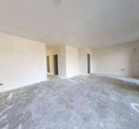 Empty room in a family house with a concrete floor and white walls.