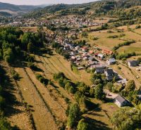 Aerial view of houses and meadows in Čierny Balog, Školská Street surrounded by recreational land.