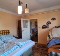 Bedroom in a family house with a double bed, blankets, and pendant lighting.