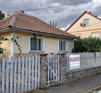 A family house in Tornyosnémeti with a brick roof and a colorful fence.
