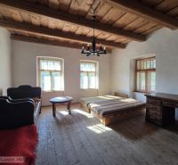 A bedroom in a family house with a wooden ceiling and a floor with a wooden decor.