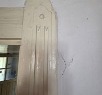 The interior of a family house with a crack in the wall near the door.