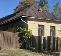 An older family house in Hejce with a sloped roof and a wooden fence.