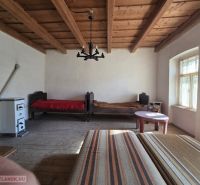 A room in a family house with a wooden ceiling and a tiled stove.