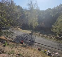 A peaceful exterior of a family house in Hejce with a landscaped garden and a paved road.