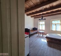 A room in a family house with a wooden ceiling and simple furniture.