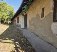 A family house in Hejce in need of renovation, with old plaster and a landscaped garden.
