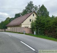A family house in Staškov with a metal roof, surrounded by trees and a fence.