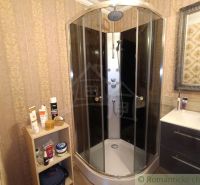 Bathroom in a family house with a round shower cabin and a mirror.