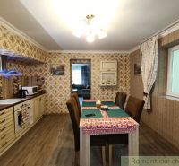 Interior of a family house with a wooden decor floor, dining table, and wallpapers.