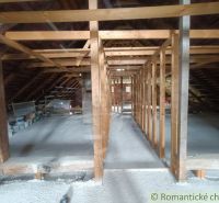 The attic of a family house in Staškov with roof beams and stored items.