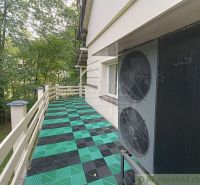 A family house in Staškov has a terrace with colorful tiles and surrounding trees.