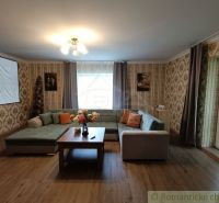 Living room in a family house with a sofa, wooden decor flooring, and a projector.