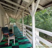 The veranda of a family house in Staškov with a colorful floor and a view of the greenery.