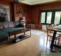Living room in a cottage with cozy seating and a wooden decor floor.