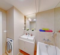 The bathroom in the 2-room apartment with a modern sink cabinet and washing machine feels cozy.