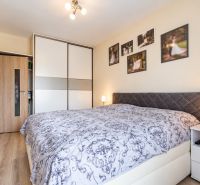 Bedroom with a built-in wardrobe, in a 3-room apartment; floor with wood decor.
