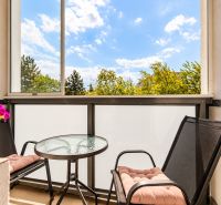 Furnished balcony with a round table and two chairs in a 3-room apartment.