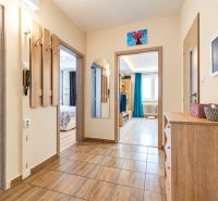 Entrance hallway in a 3-room apartment, bright interior with wood-patterned flooring.
