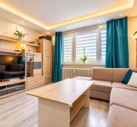 Living room with a sofa set, television, and wooden decor flooring in a 3-room apartment.