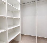 Storage space with white shelves in a 2-room apartment.