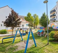 A children's playground surrounded by buildings with colorful murals on Sancova Street.