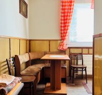 A kitchenette in a 3-room apartment with wooden decor and seating with a table.