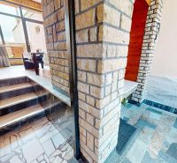 Interior of a family house with stone-clad stairs and a glass wall.