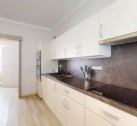 Bright kitchen with sliding doors and wood-patterned flooring in a family house.