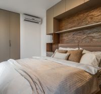 Bedroom with a double bed, built-in wardrobes, and a floor with a wooden decor. Apartment construction.