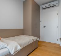 Single room with a bed, built-in wardrobe, and wood-patterned flooring.