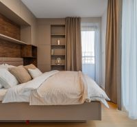 Bright bedroom with beige curtains, shelves, and a wooden decor floor in the apartment construction project.