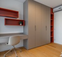 Interior with an office desk, storage cabinets, and a wood-patterned floor. Apartment construction.