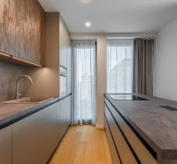 Modern kitchen with wood-patterned flooring and light curtains, Apartment construction.